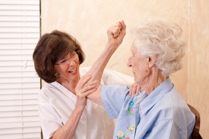 During National Physical Therapy Month, a nurse is assisting an elderly woman with her arm.
