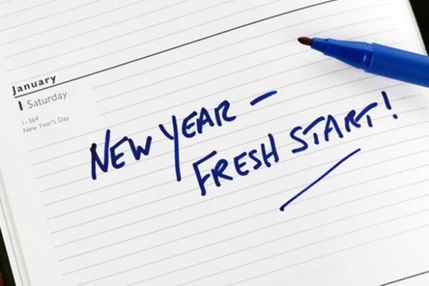 A notebook inspiring you to keep your New Year's resolutions with the words new year fresh start on it.