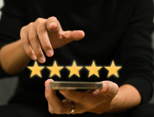A doctor holding a smartphone with five stars on it, showcasing successful marketing strategies.